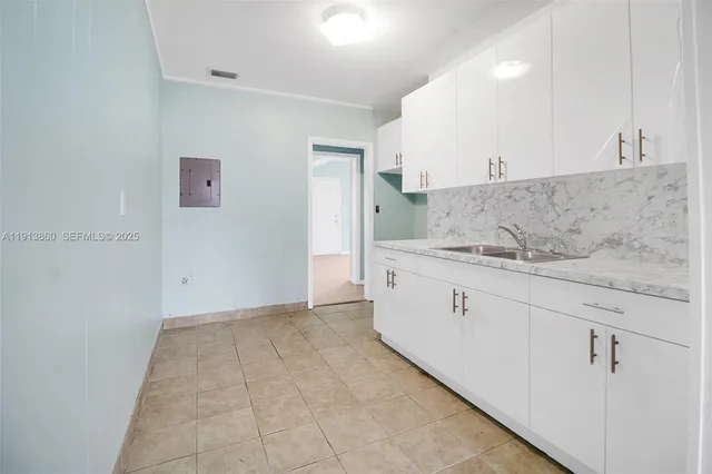 a view of kitchen with granite countertop cabinets and sink