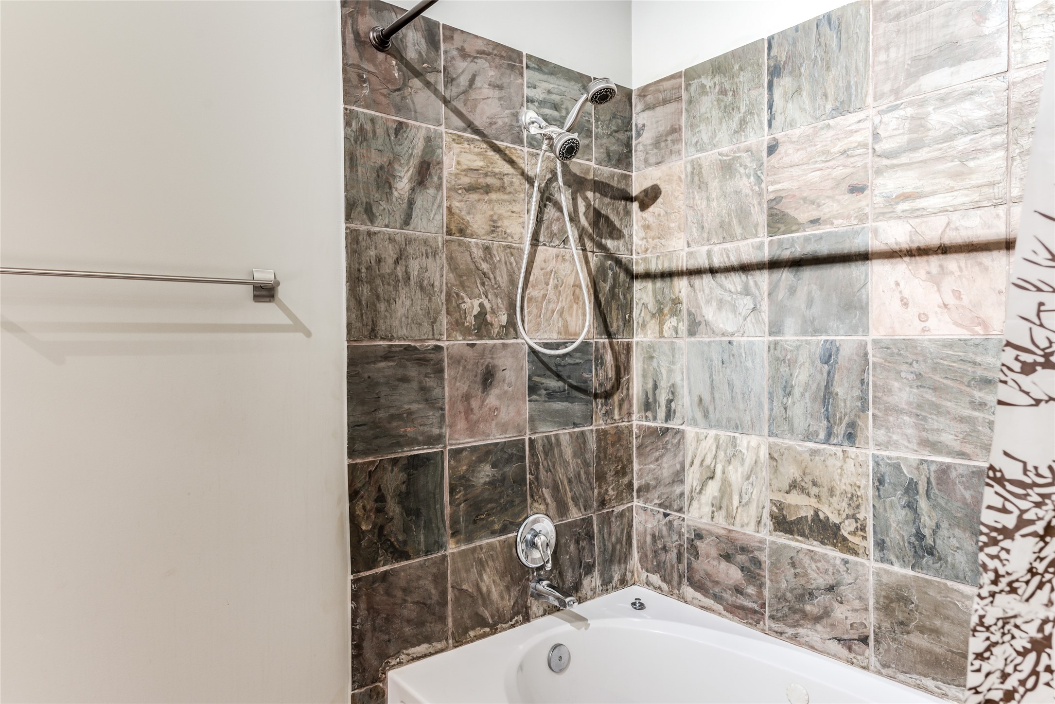 705 Main Street, Unit 215 Houston, TX 77002 - Photo 18 of 36 This bathroom features a tub-shower combination with a modern tile surround, offering a clean and stylish look.
