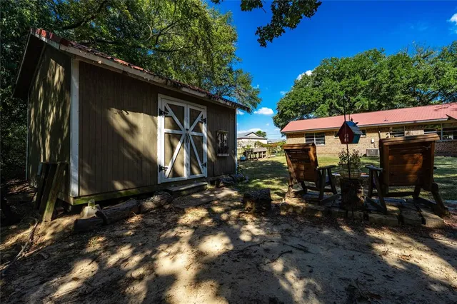 a backyard of a house with barbeque oven table and chairs