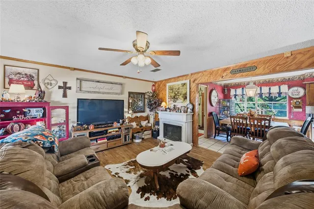 a living room with furniture a flat screen tv and a large window