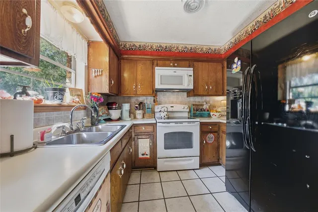 a kitchen with a sink appliances cabinets and a counter top space