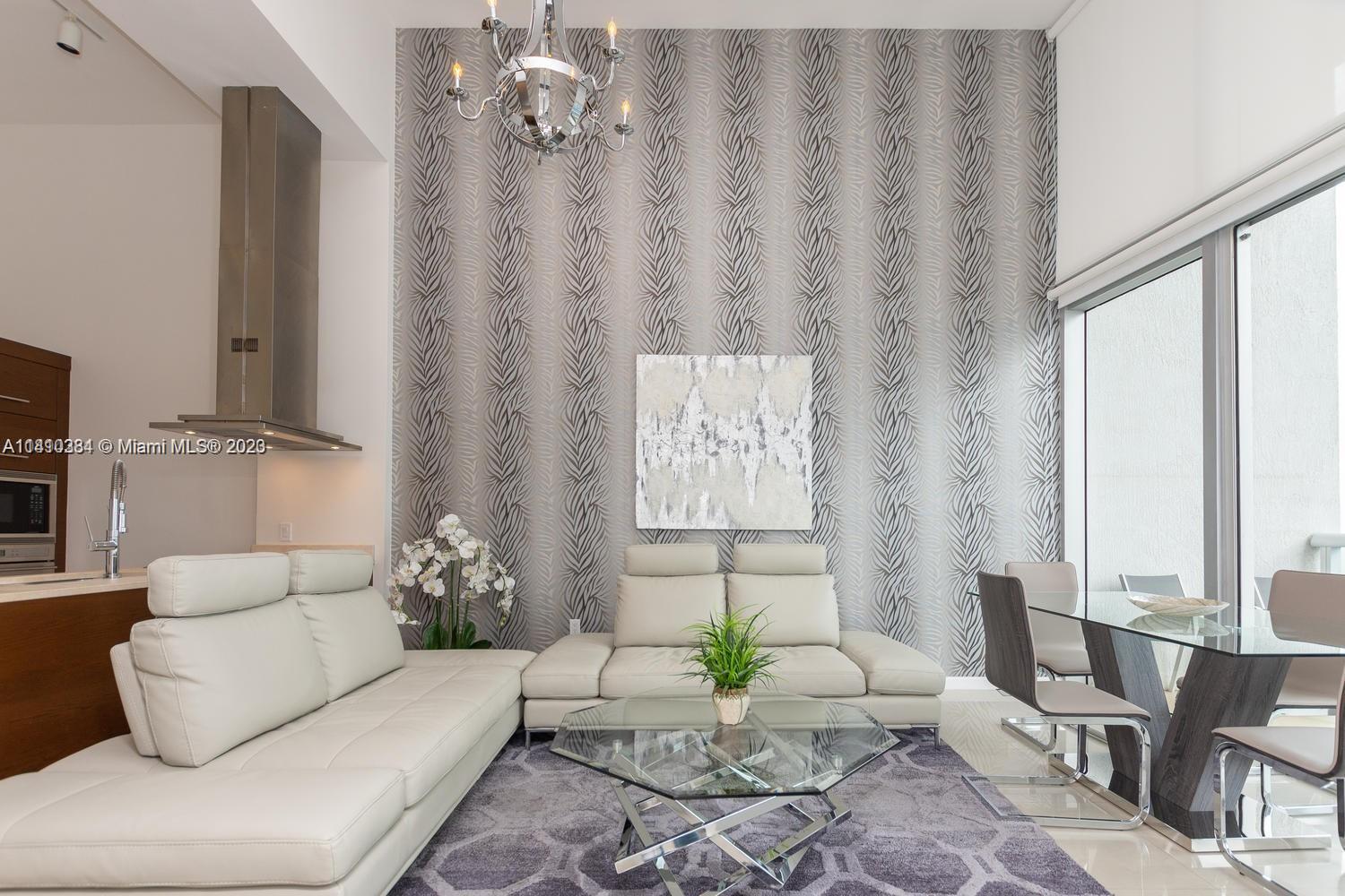 485 Brickell Avenue, Unit 2803 Miami, FL 33131 - Photo 3 of 9 a living room with furniture and floor to ceiling windows