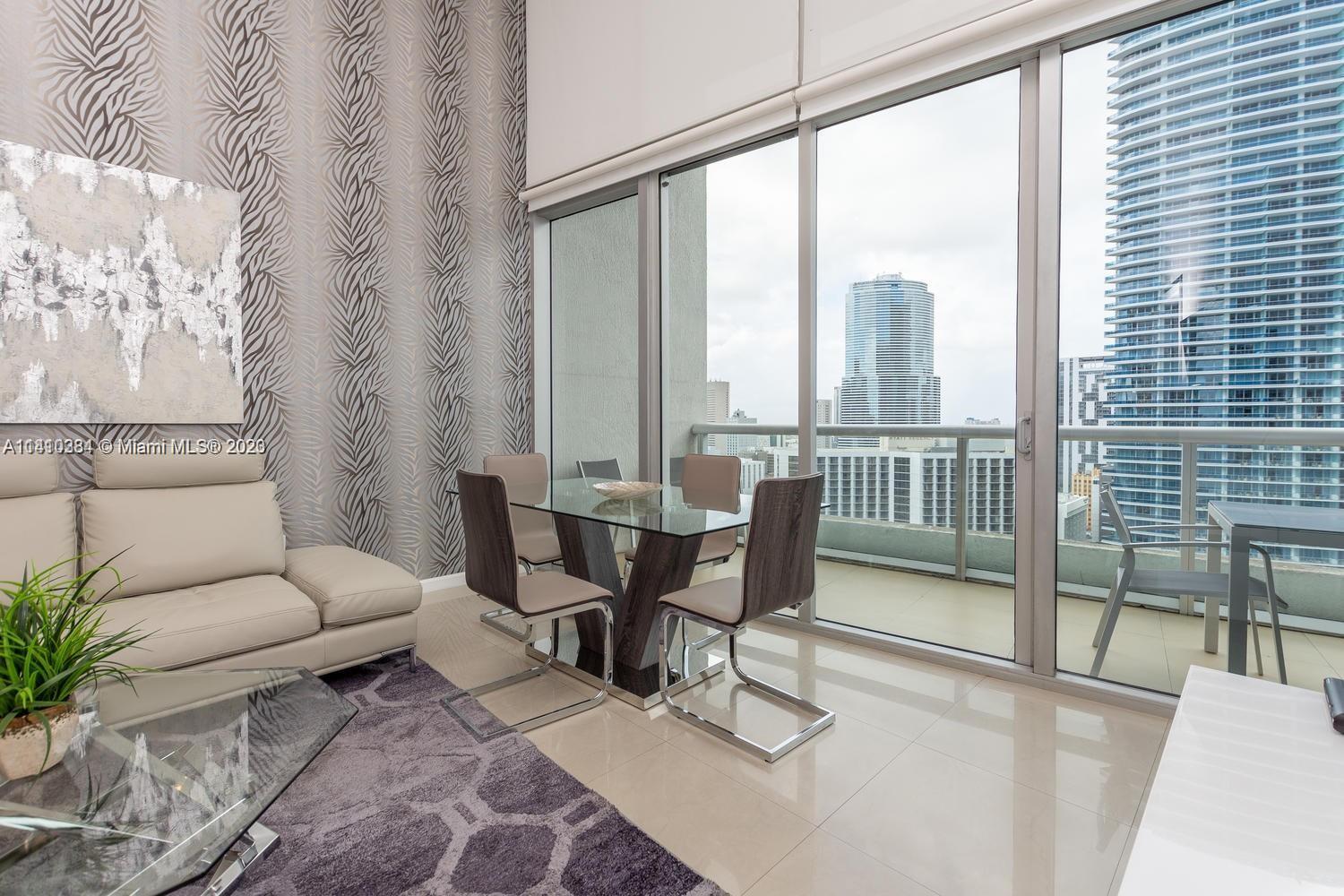 485 Brickell Avenue, Unit 2803 Miami, FL 33131 - Photo 4 of 9 a living room with furniture and a floor to ceiling window