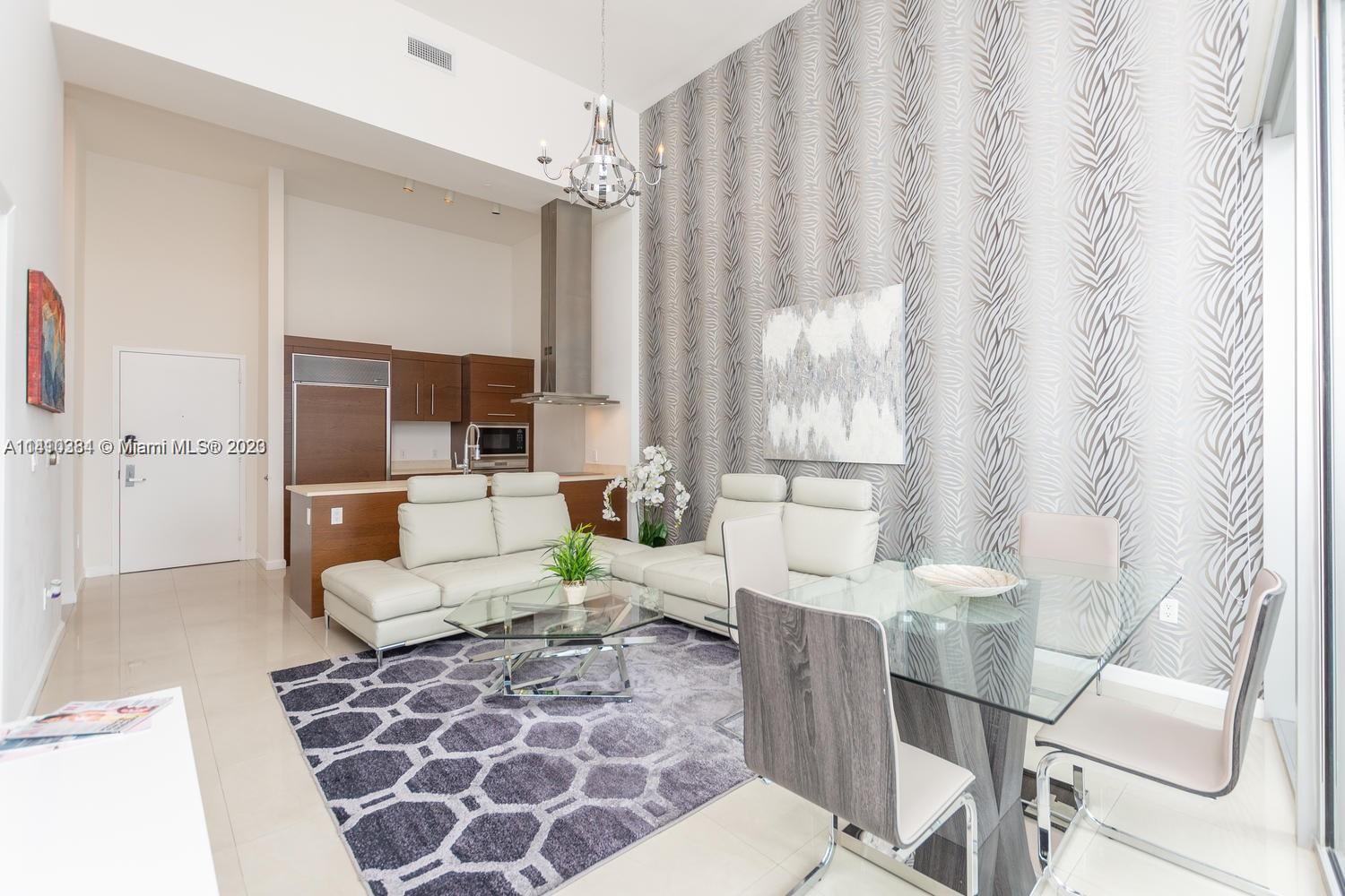 485 Brickell Avenue, Unit 2803 Miami, FL 33131 - Photo 5 of 9 a living room with furniture and a lamp