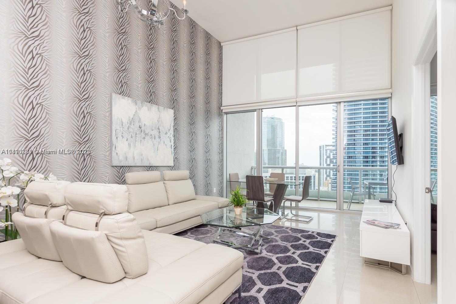 485 Brickell Avenue, Unit 2803 Miami, FL 33131 - Photo 7 of 9 a living room with furniture and a large window