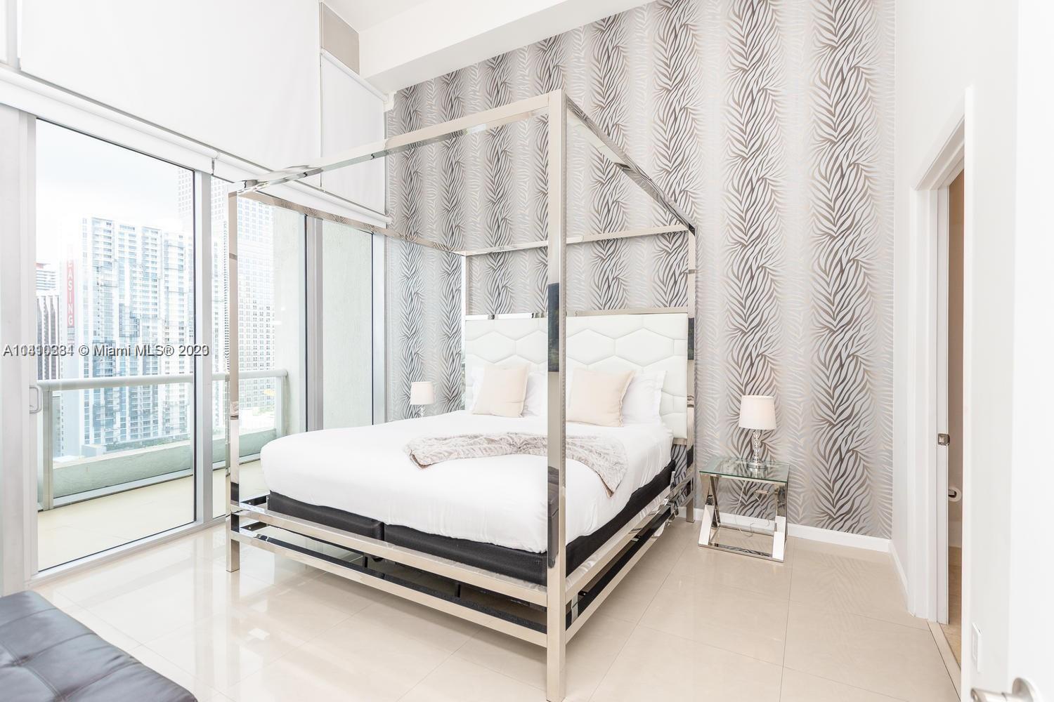 485 Brickell Avenue, Unit 2803 Miami, FL 33131 - Photo 8 of 9 a bed sitting in a spacious bedroom next to a window