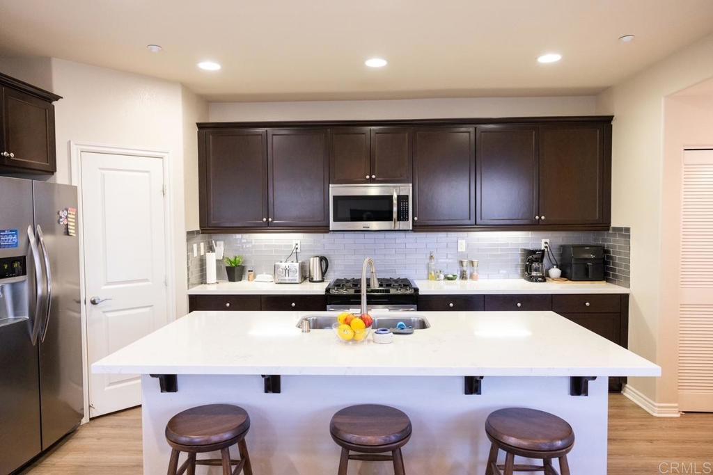 2332 Sentinel Lane San Marcos, CA 92078 - Photo 4 of 24 a kitchen with stainless steel appliances a stove a sink a microwave a refrigerator and cabinets