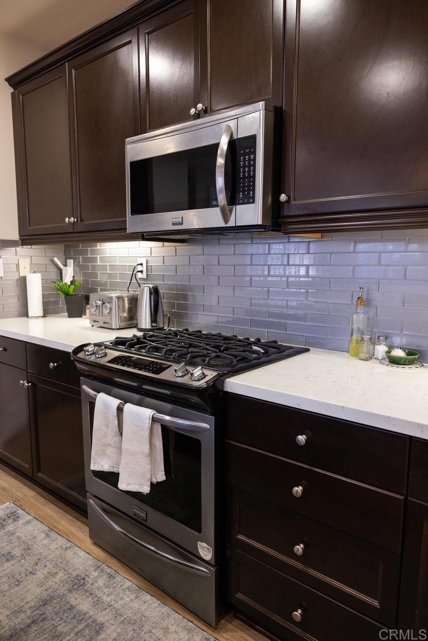 2332 Sentinel Lane San Marcos, CA 92078 - Photo 5 of 24 a kitchen with stainless steel appliances a stove a microwave a sink and cabinets