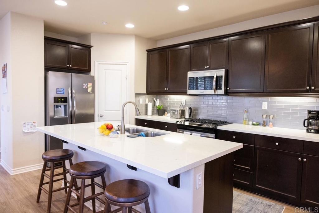 2332 Sentinel Lane San Marcos, CA 92078 - Photo 6 of 24 a kitchen with a sink a stove and chairs