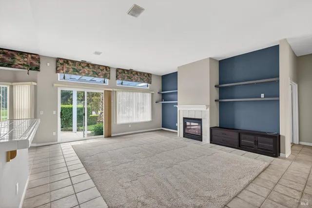 a view of an empty room with a fireplace and a window