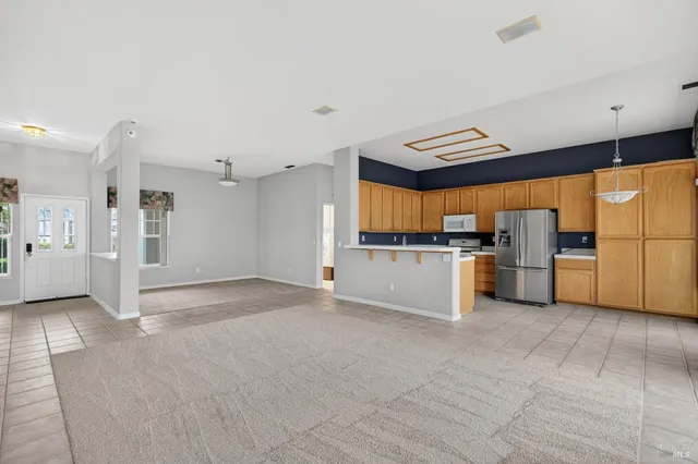 a view of a kitchen with a sink and dishwasher a refrigerator with wooden floor