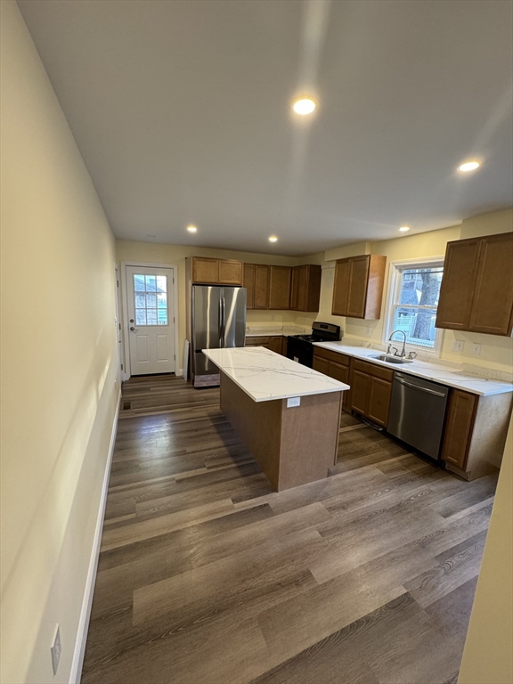 a large room with kitchen island a stove a sink dishwasher and a oven with granite countertops