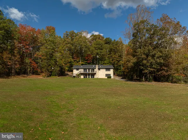 a view of a house with a yard and sitting area