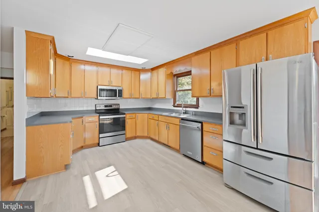 a kitchen with stainless steel appliances granite countertop a refrigerator sink and cabinets
