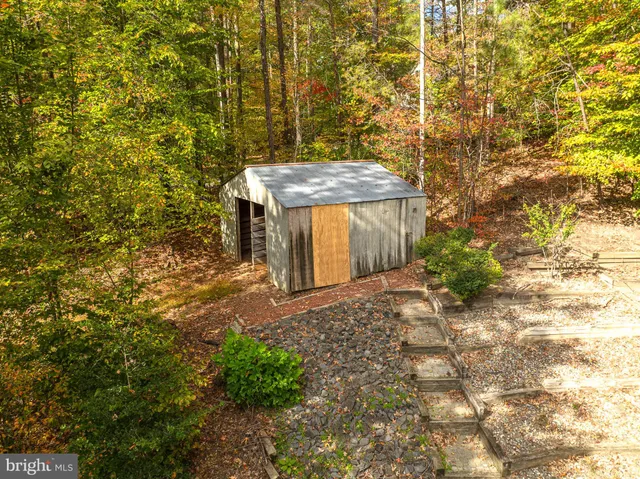 a view of a yard with plants and brick wall