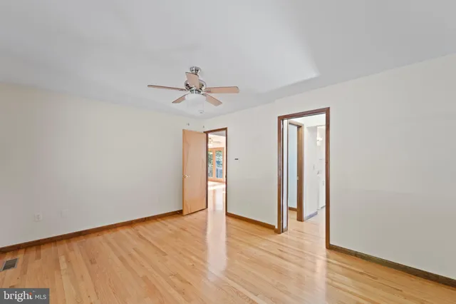 a view of a room with wooden floor and ceiling fan