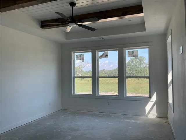 a view of room with a ceiling fan and a window