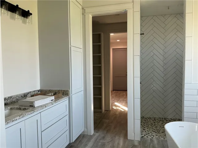 a bathroom with a granite countertop bathtub sink and toilet