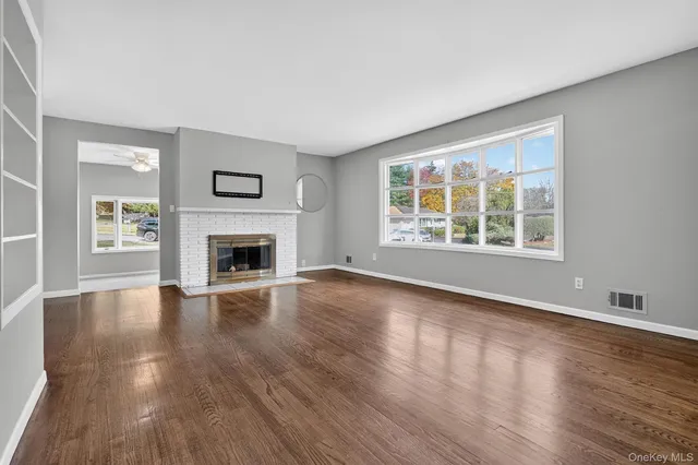 wooden floor fireplace and windows in an empty room