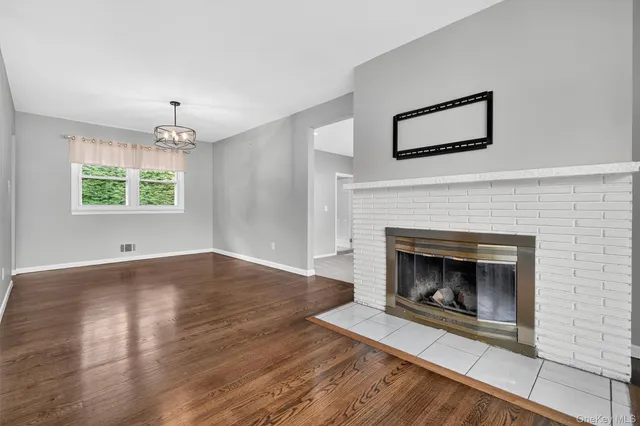 a view of a livingroom with a fireplace wooden floor and windows