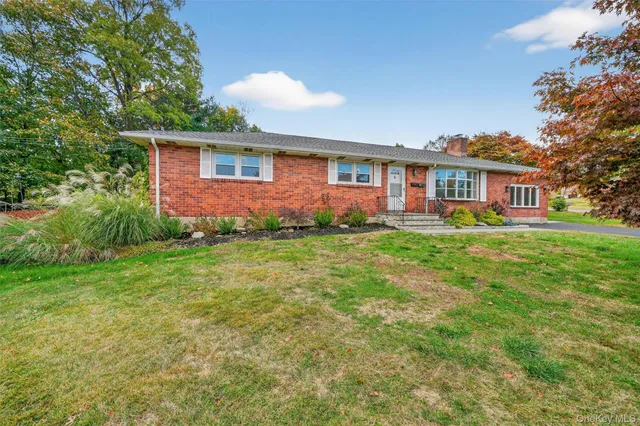 a front view of a house with a yard and trees