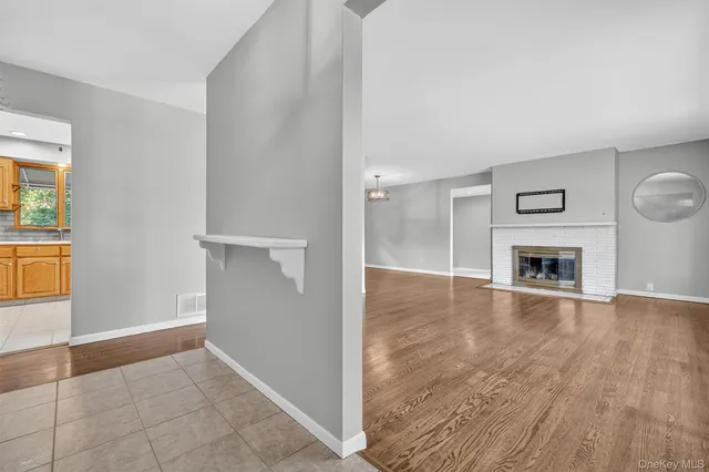 an empty room with wooden floor a fireplace and windows