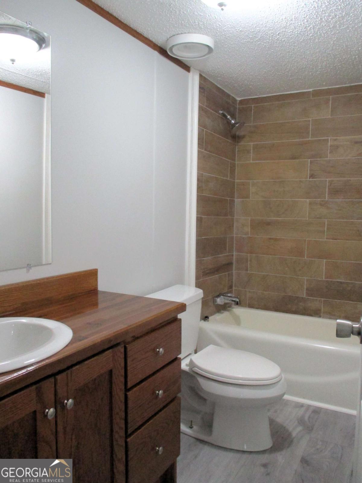 606 Cline Road Northwest Resaca, GA 30735 - Photo 11 of 49 a bathroom with a granite countertop sink toilet a mirror and shower
