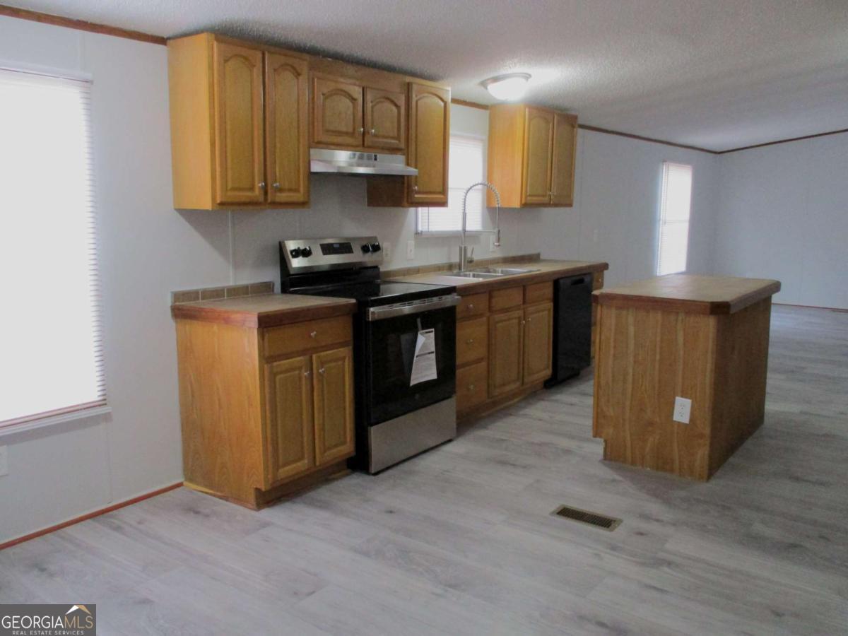 606 Cline Road Northwest Resaca, GA 30735 - Photo 24 of 49 a kitchen with stainless steel appliances granite countertop a stove a sink and a microwave