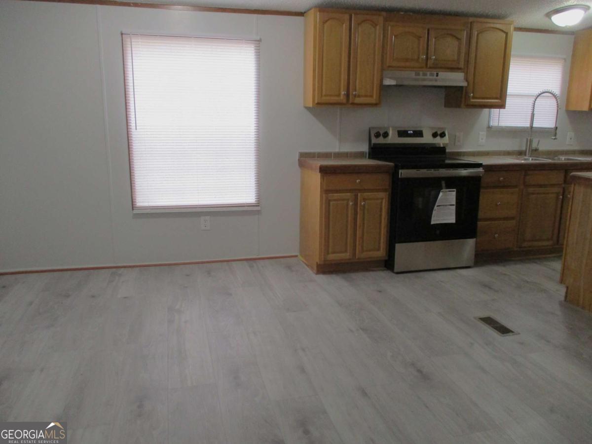 606 Cline Road Northwest Resaca, GA 30735 - Photo 34 of 49 a kitchen with stainless steel appliances granite countertop a stove a sink and a microwave