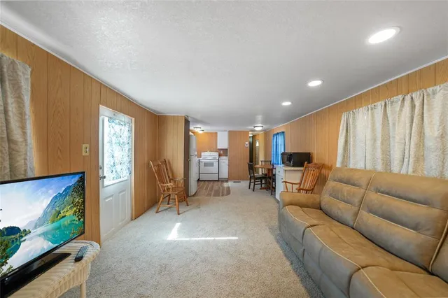 a living room with furniture a flat screen tv and large window