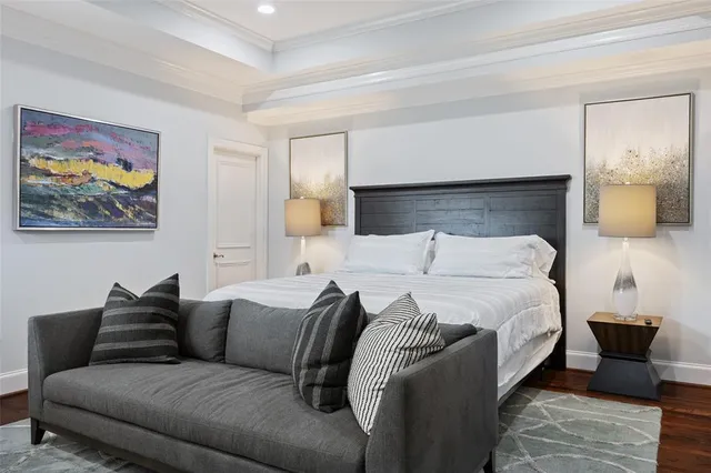 a bedroom with a bed a couch and a flat screen tv