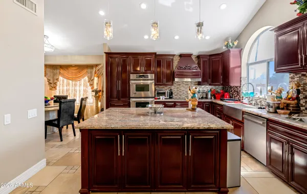 a kitchen with stainless steel appliances granite countertop a stove and cabinets