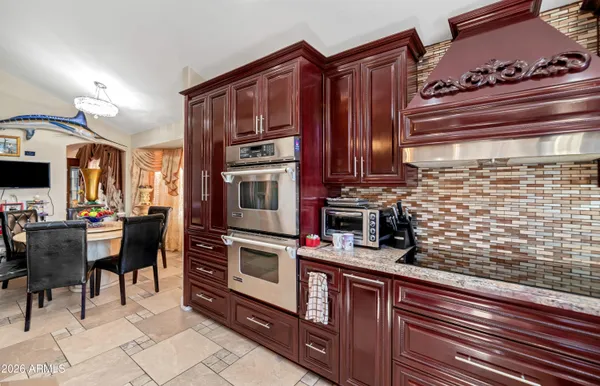 a kitchen with stainless steel appliances a dining table chairs stove refrigerator and microwave