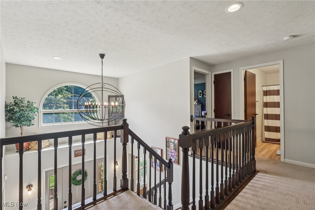 230 South Medina Line Road Akron, OH 44321 - Photo 16 of 50 Hallway with an upstairs landing, a chandelier, recessed lighting, carpet flooring, and a textured ceiling