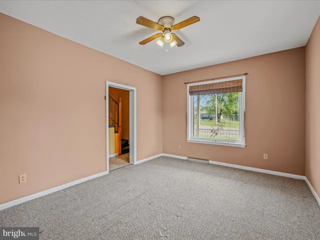 an empty room with closet and a ceiling fan
