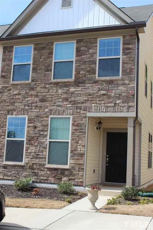 a front view of a brick house with a yard and garage