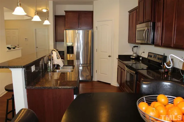 a kitchen with sink a refrigerator and cabinets