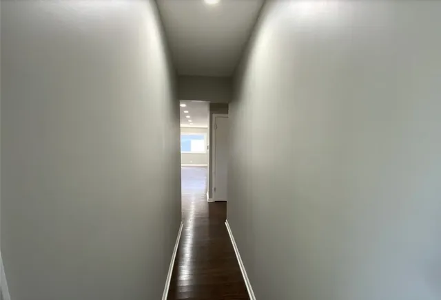 a white toilet sitting next to a white wall