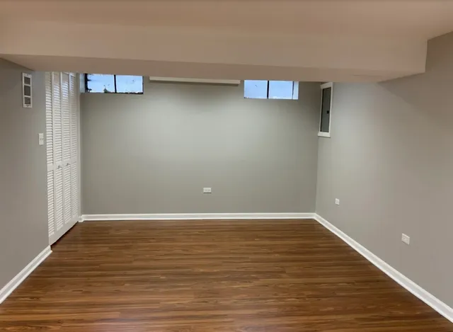 a view of an empty room with wooden floor