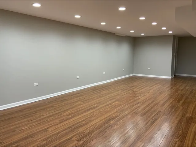 an empty room with wooden floor and entrance