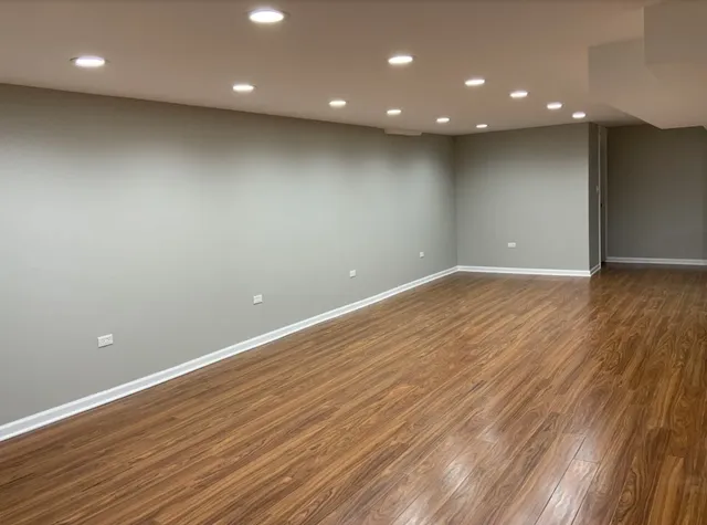 a view of empty room with wooden floor