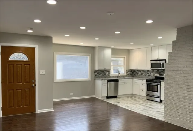 a kitchen with stainless steel appliances granite countertop a stove a sink and a refrigerator