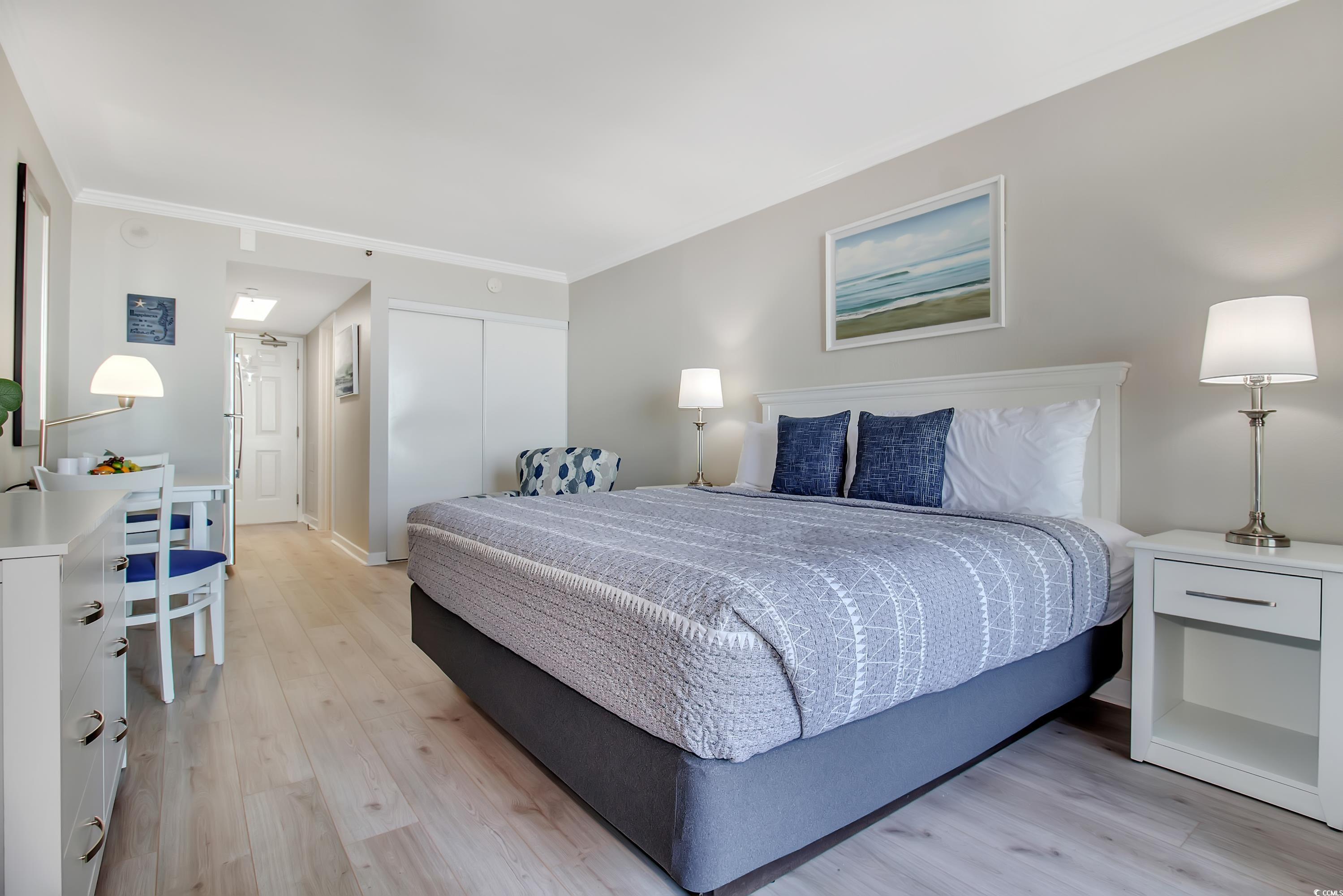 2710 North Ocean Boulevard, Unit 622 Myrtle Beach, SC 29577 - Photo 24 of 37 Bedroom featuring crown molding, light wood-style flooring, and a closet