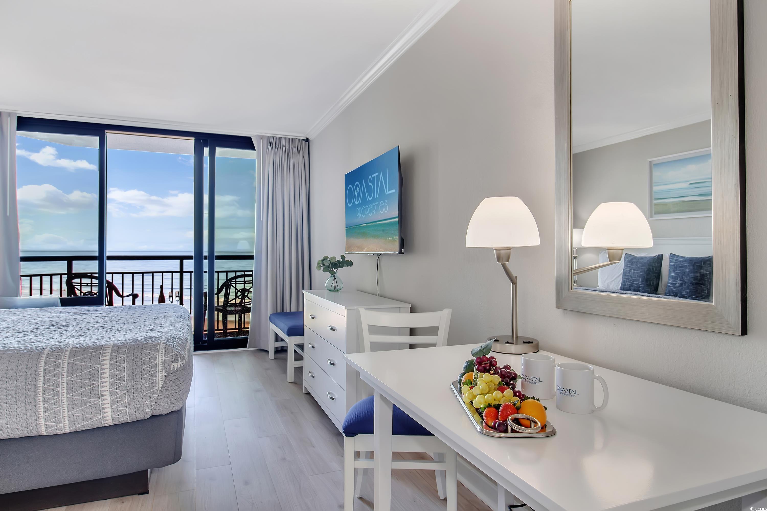 2710 North Ocean Boulevard, Unit 622 Myrtle Beach, SC 29577 - Photo 29 of 37 Bedroom with expansive windows, light wood-type flooring, access to exterior, and ornamental molding