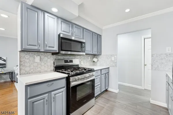 a kitchen with stainless steel appliances granite countertop a stove a sink and a microwave