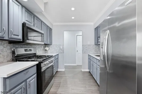 a kitchen with stainless steel appliances granite countertop a stove a refrigerator and a microwave