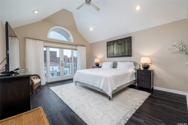 a spacious bedroom with a bed and wooden floor