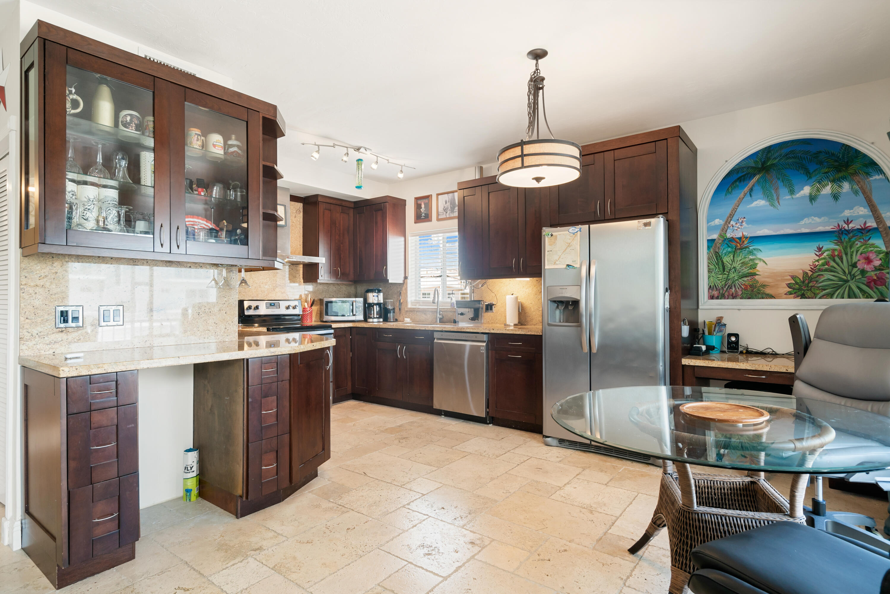 311 Buttonwood Circle Key Largo, FL 33037 - Photo 16 of 38 a kitchen with stainless steel appliances granite countertop a refrigerator a sink dishwasher a stove and a dining table with wooden floor