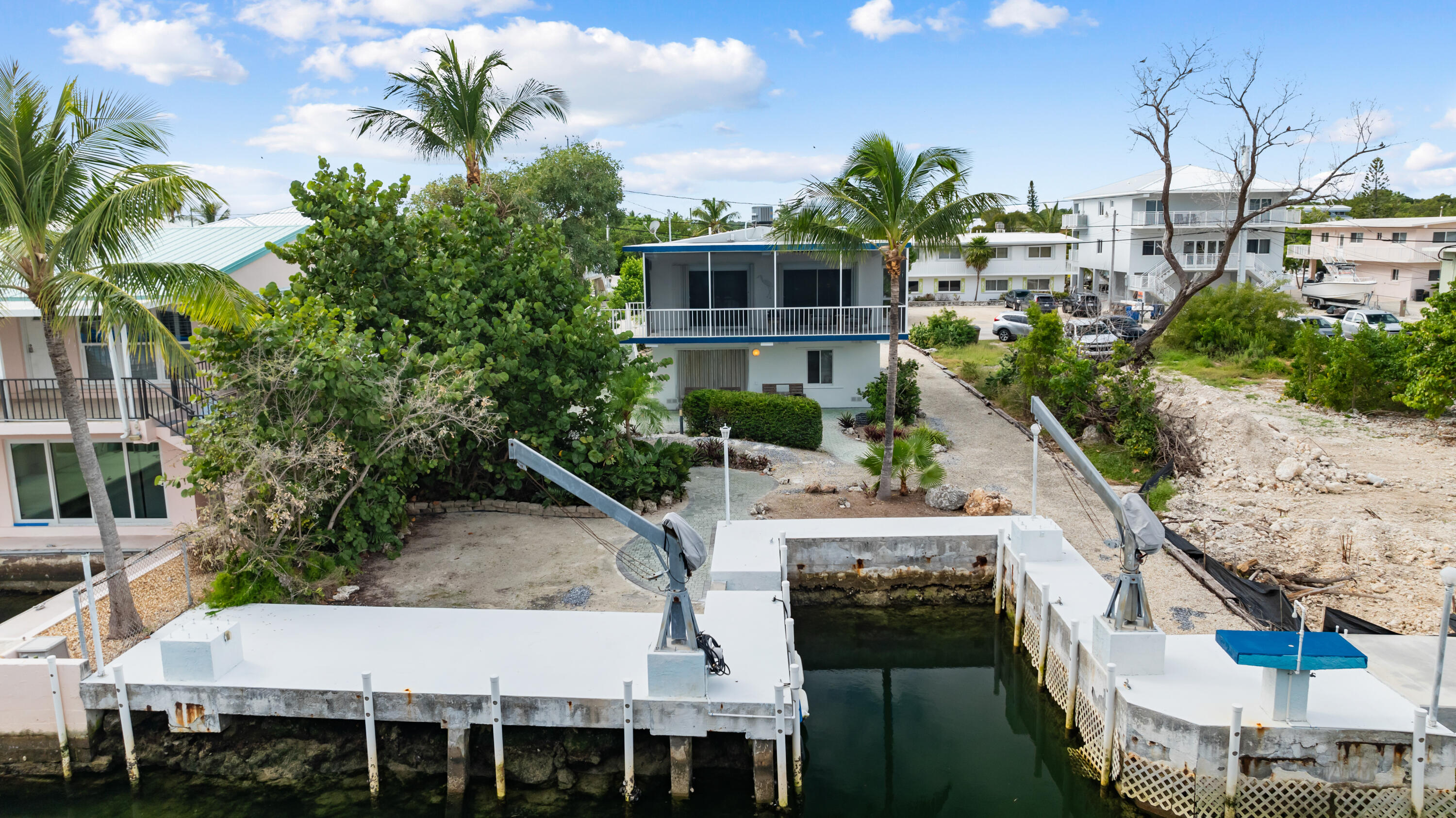 311 Buttonwood Circle Key Largo, FL 33037 - Photo 6 of 38 a view of a white house with a yard plants and seating space
