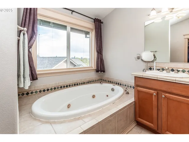 a bathroom with a tub sink and mirror